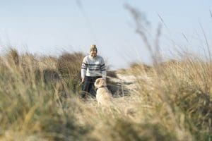 Young Woman spending time with her dog on the beach